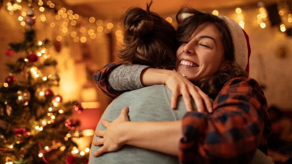 Two People Hug at a Holiday Party